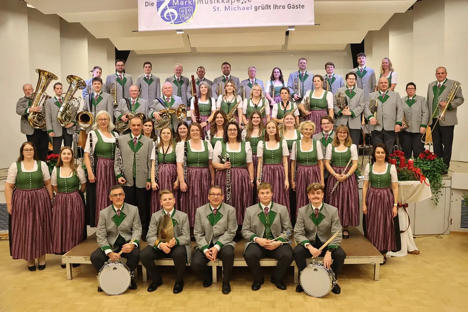 Eine Musikkapelle in Tracht steht auf einer Bühne