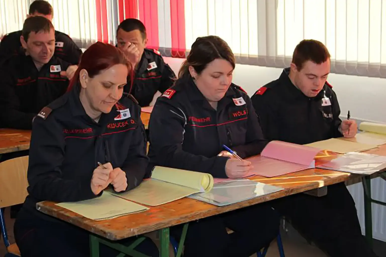 Thörl: Feuerwehren auf dem Prüfstand Mehrere Personen in Uniformen sitzen an Tischen und schreiben
