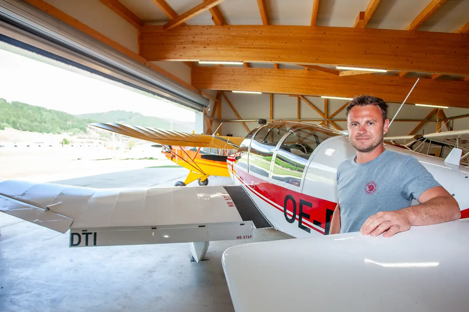 Traboch-Timmersdorf: Fliegerclub hat runden Geburtstag Ein Mann steht an ein Motor-Kleinflugzeug gelehnt in einer Halle