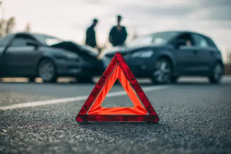 Ablenkung ist Unfallursache Nummer eins Ein Pannendreieck steht auf einer Straße vor einem Verkehrsunfall