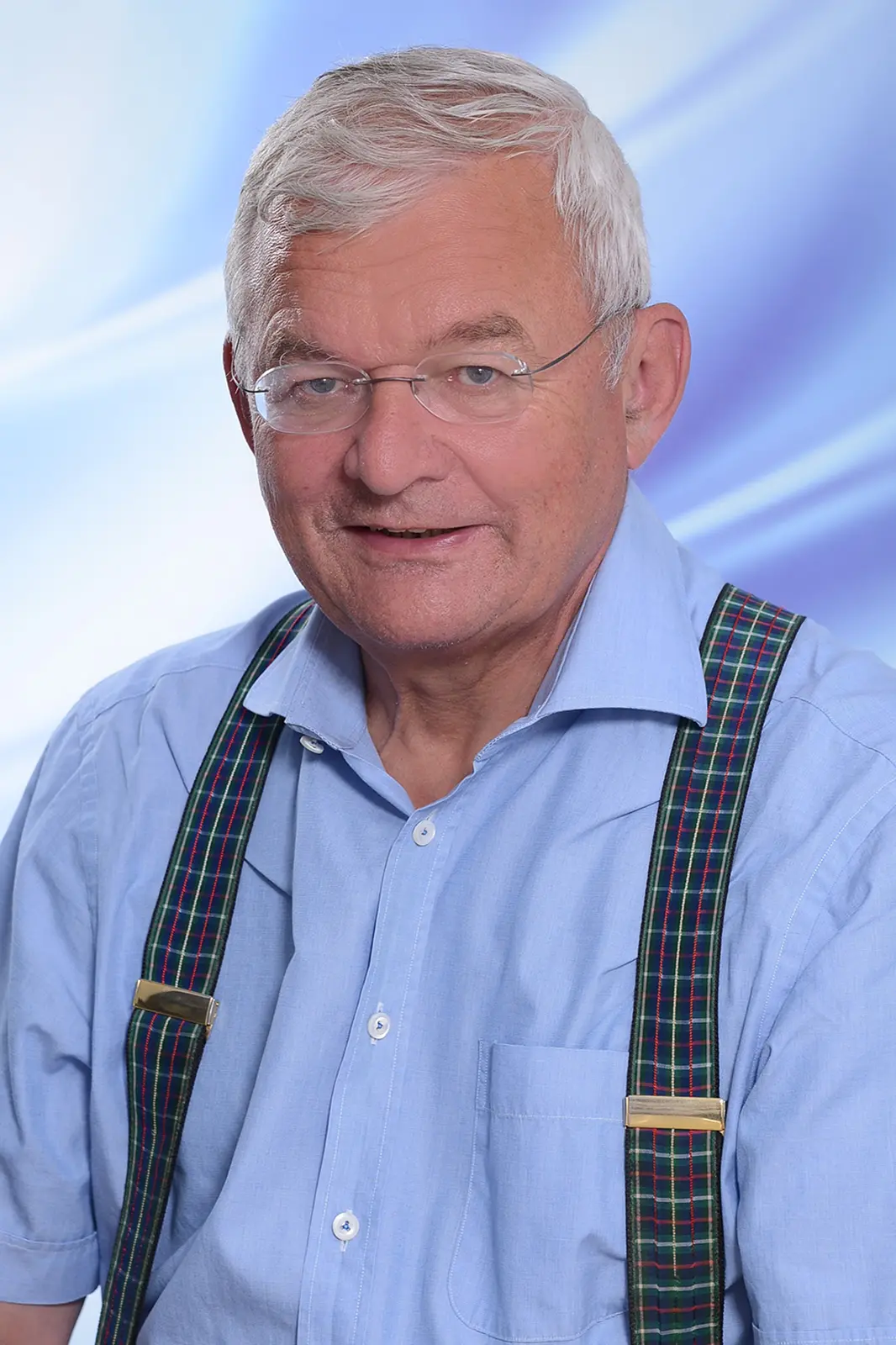 Ein älterer Mann mit Brille und Hosenträgern