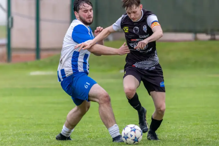 Zwei Spieler kämpfen um den Ball.