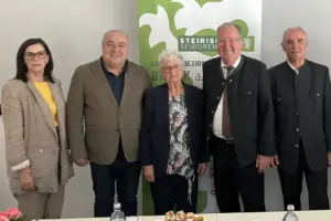 Zwei Frauen und drei Männer stehen vor einer Wand