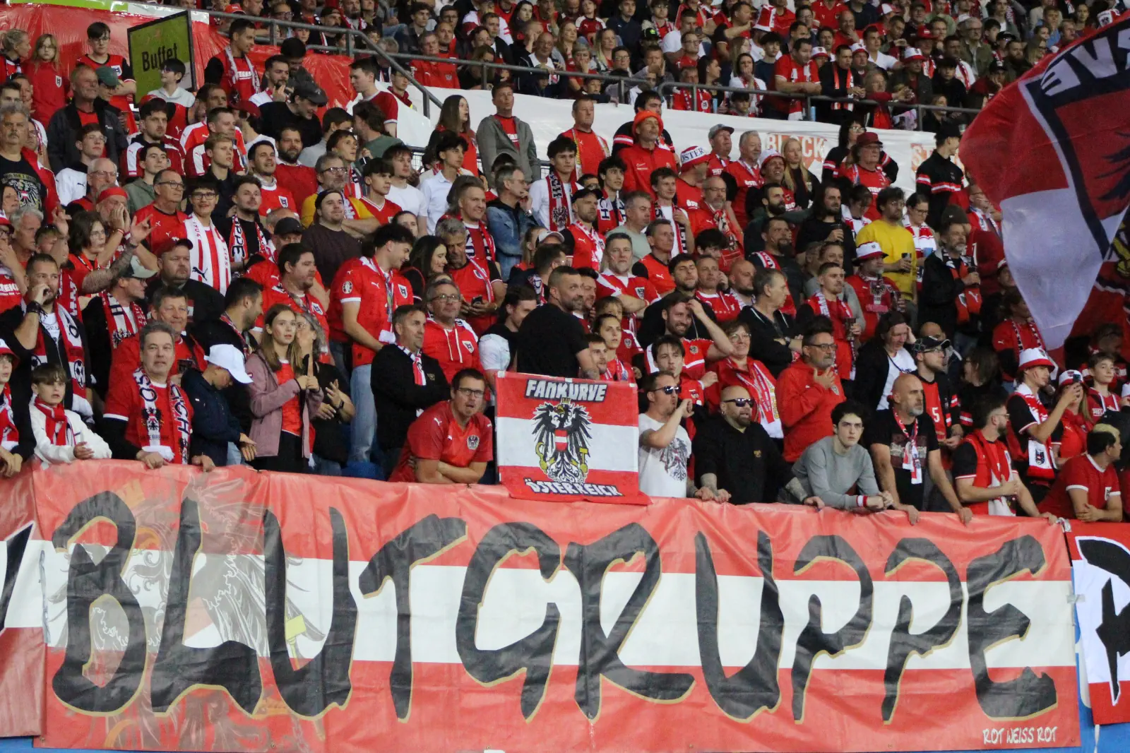 Jede Menge Fußballfans hinter einem Banner der Blutgruppe Rot Weiß Rot