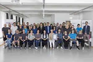 Hohe Auszeichnung für Physio und Reha Bruck Eine große Gruppe von Personen präsentiert eine Ukrunde