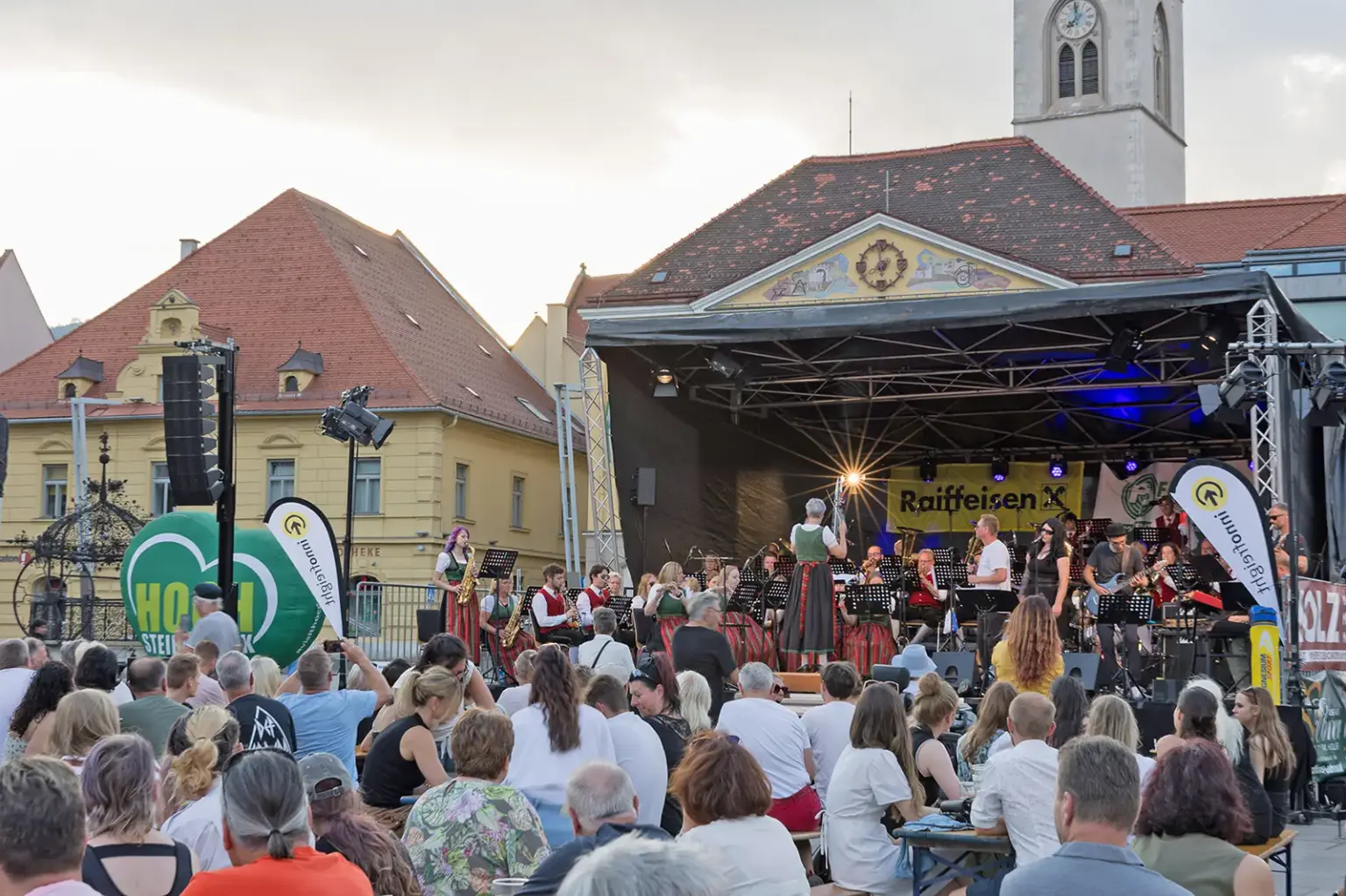 Bruck: Mix aus Blas- und Rockmusik Eine Open-Air-Bühne mit MusikerInnen und vielen ZuschauerInnen davor