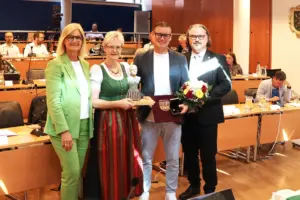 Zwei Männer und zwei Frauen präsentieren Auszeichnungen