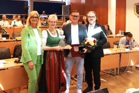 Zwei Männer und zwei Frauen präsentieren Auszeichnungen