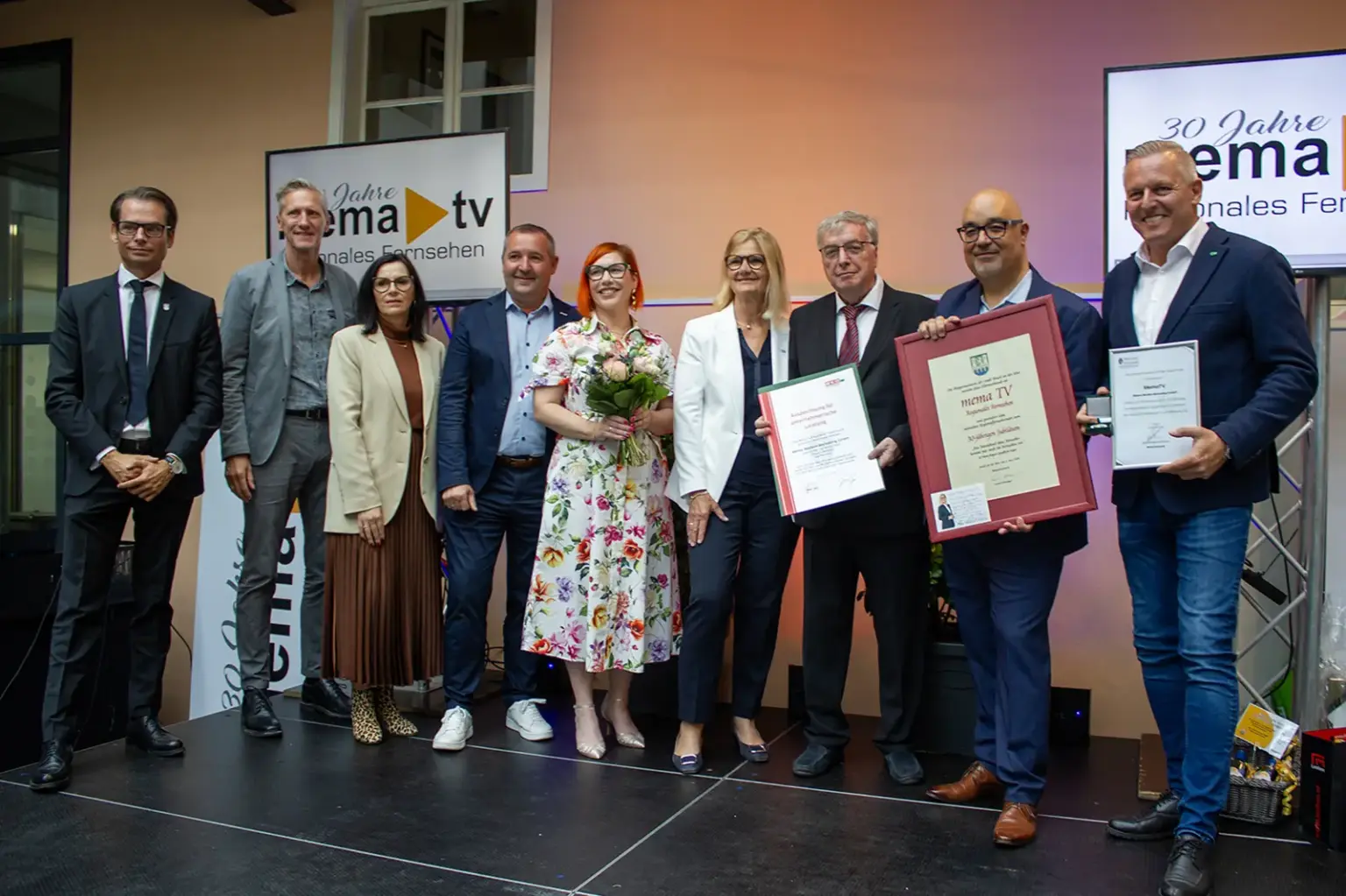 30 Jahre Regionalfernsehen Mema TV Eine Gruppe von Personen mit Blumen und Urkunden