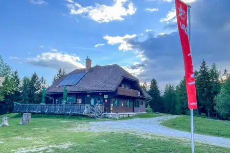 Naturfreunde Bruck feiern 125 Jahre Ein Schutzhaus mit Terrasse und eine rote Flagge auf einem Berg