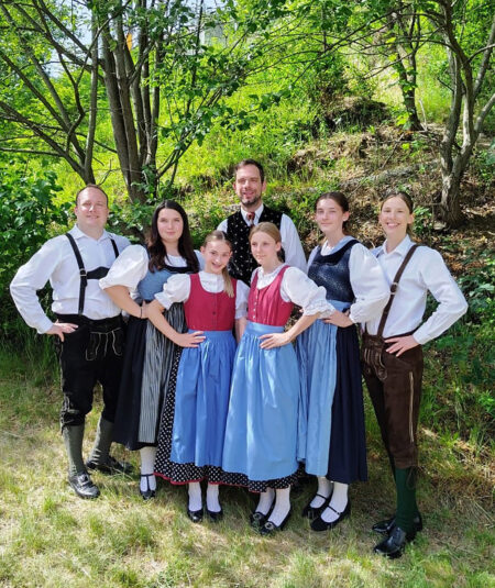 Kapfenberg: Prüfung erfolgreich absolviert Eine Gruppe von Jugendlichen und Erwachsenen in Tracht stehen unter einem Baum