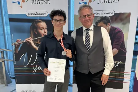 Preisgekrönte Nachwuchsmusiker aus Kapfenberg Ein Jugendlicher mit Medaille und Urkunde steht neben einem Erwachsenen