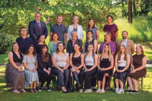 Eine Gruppe von Mädchen mit einigen Erwachsenen posiert auf einer Wiese