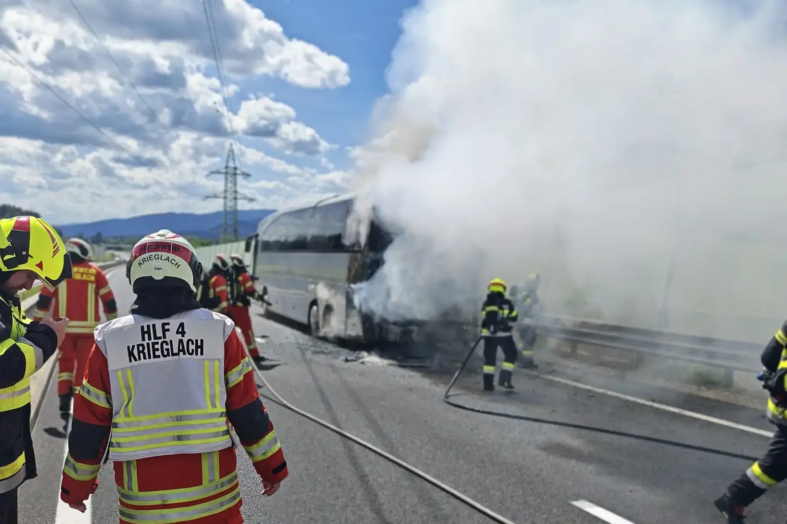 Feuerwehrkräfte bekämpfen einen brennenden Reisebus auf der S6. Dichter Rauch steigt auf, während Einsatzkräfte mit Löschschläuchen den Brand unter Kontrolle bringen.