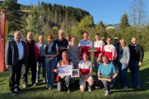Eine Gruppe von Personen steht mit Trophäen auf einer Wiese