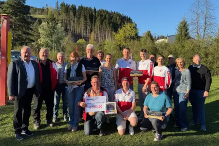 Eine Gruppe von Personen steht mit Trophäen auf einer Wiese