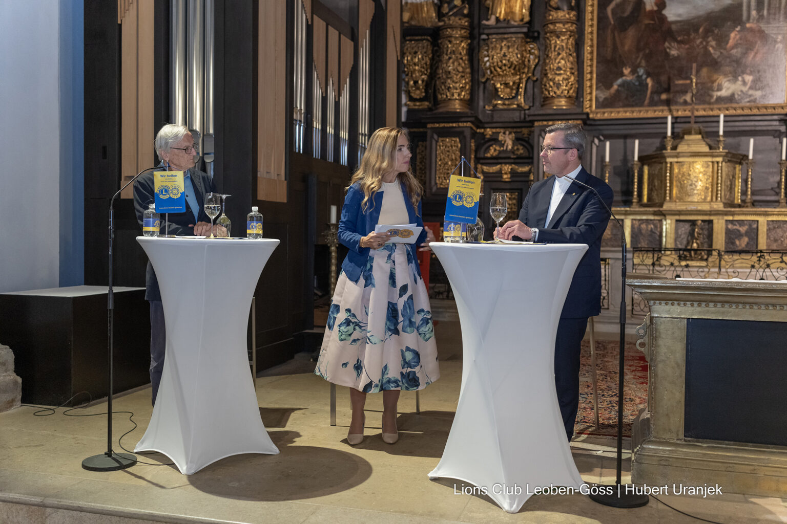 Lions-Congress in Leoben Zwei Männer stehen mit einer Frau an Rednerpulten in einer Kirche