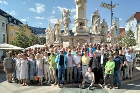 Eine große Gruppe von Personen posiert vor einem Denkmal