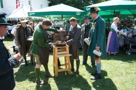 Kirchtag auf der Leobener Massenburg Mehrere Personen in Tracht beim Bieranstich auf einer Festwiese