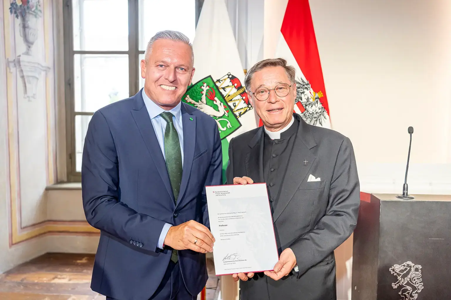 Zwei Männer in Anzügen bei einer Preisverleihung