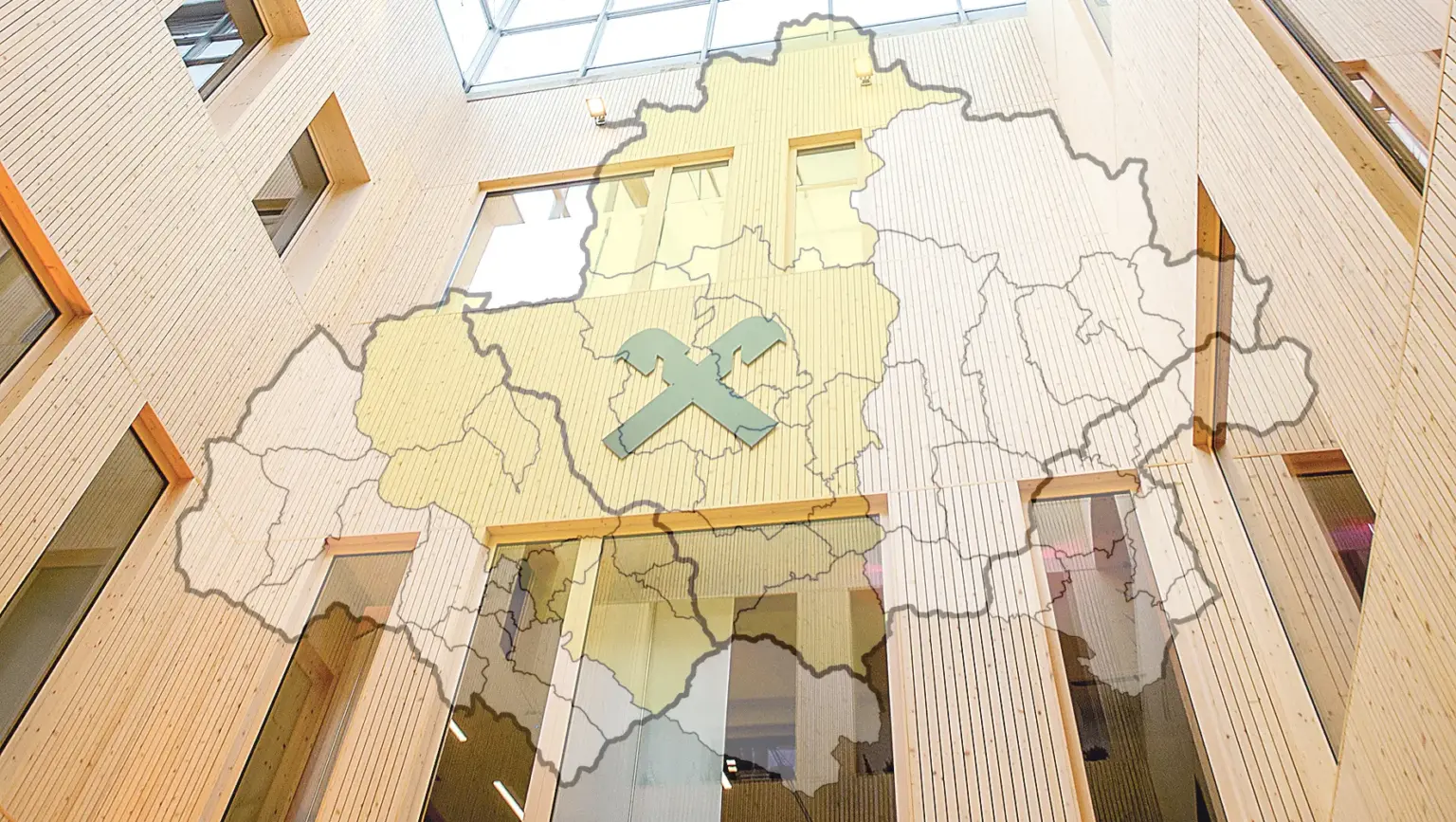 Fotomontage aus einer Landkarte und einer Holzfassade mit dem Raiffeisen-Logo darauf