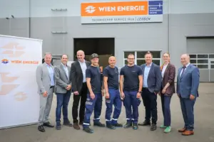 Zehn Personen stehen vor dem Technischen Service Hub von Wien Energie in Leoben für ein Gruppenfoto. Mitarbeitende in Arbeitskleidung und Vertreter aus Wirtschaft und Politik posieren gemeinsam vor dem Betriebsgebäude.