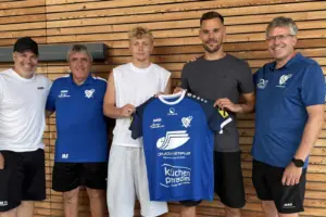 Fußballverein präsentiert mit Lukas Graf einen Neuzugang, der gemeinsam mit Funktionären sein neues Trikot vorstellt.
