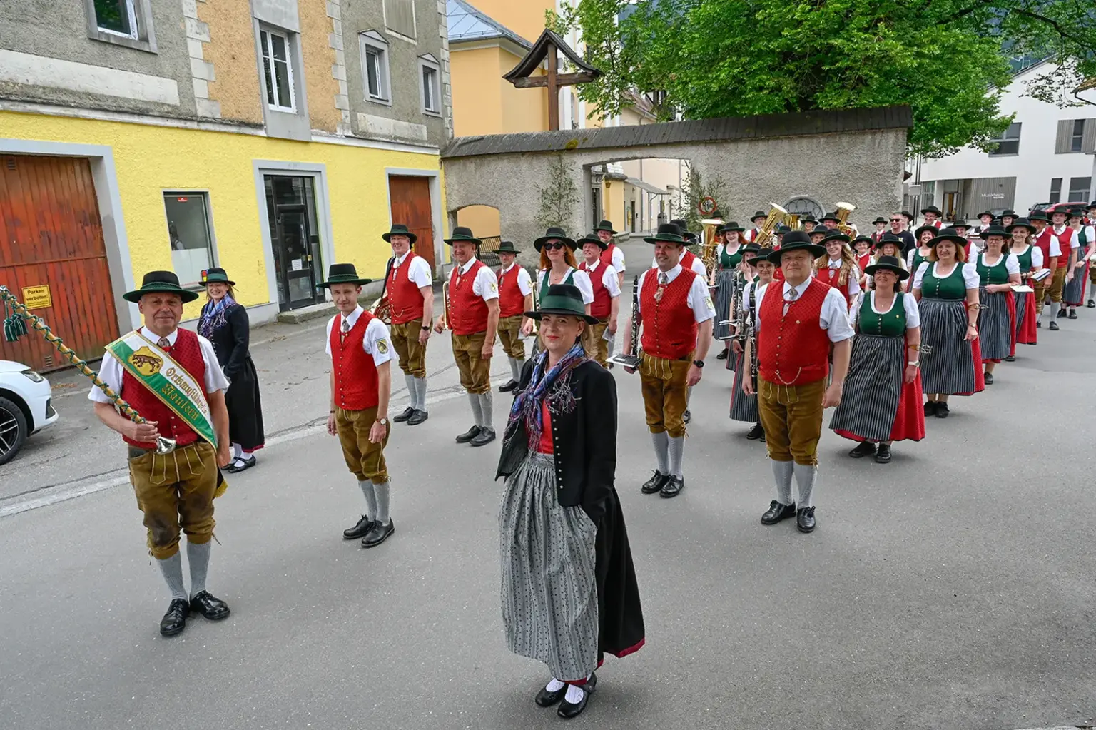 Eine Musikkapelle in Tracht steht auf einer Straße