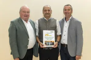 Drei Männer präsentieren eine Festschrift