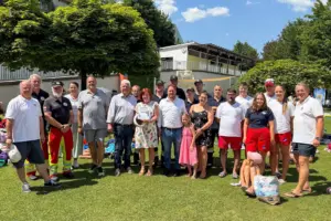 Eine Gruppe von Personen steht auf einer Wiese