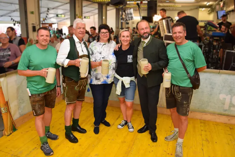 Musik, Kulinarik und Tradition in Niklasdorf Vier Männer und zwei Frauen stehen mit Bierkrügen in einer Festhalle