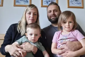 Ein Mann und eine Frau mit zwei kleinen Kindern auf dem Schoß