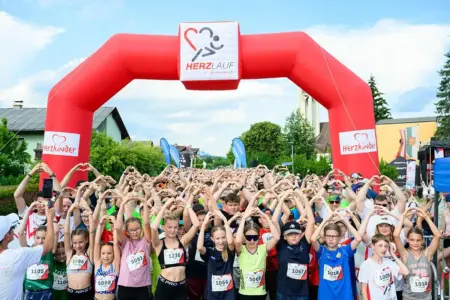2860 Starter beim Herzlauf in St. Barbara Eine große Gruppe von Kindern formt mit den Händen ein Herzzeichen