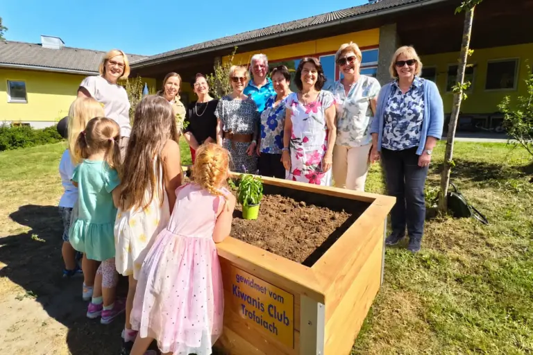 Trofaiach: Ein Hochbeet für kleine Gärtner Mehrere Erwachsene und Kinder stehen um ein Hochbeet