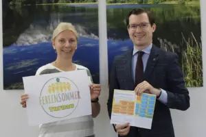 Ein Mann und eine Frau zeigen einen Programmplan
