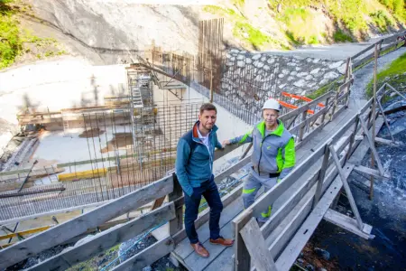 Zwei Männer auf einer Baustelle vor einer großen Stahlbetonkonstruktion