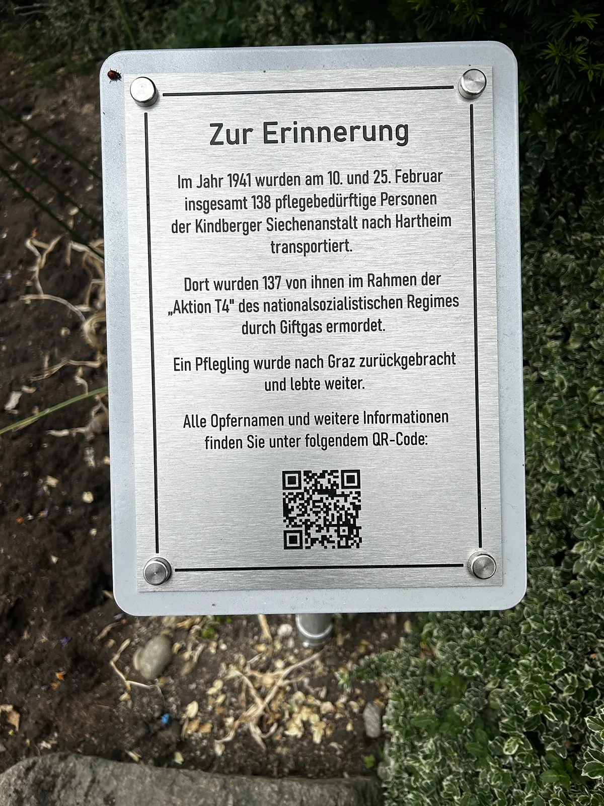 Die Inschrift einer Gedenktafel mit QR-Code.