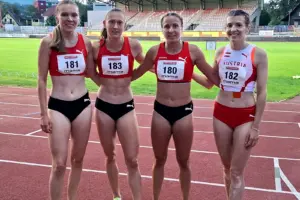 Vier Frauen in Lauf-Wettkampfkleidung in einem Leichtathletikstadion