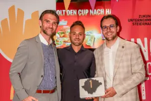 Drei Männer bei einer Preisverleihung
