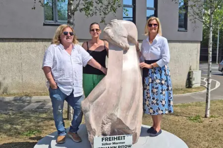 Bruck: Neue Skulptur am Grazer Tor Zwei Frauen und ein Mann stehen an einer Steinskulptur mit Pferdekopf