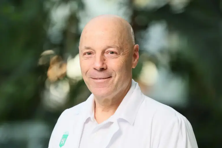 Erich Schaflinger wird neuer Kages-Chef Porträt eines lächelnden, glatzköpfigen Mannes in einem weißen Hemd. Er blickt direkt in die Kamera, der Hintergrund ist unscharf und zeigt grüne Pflanzen in einem hellen Innenraum.