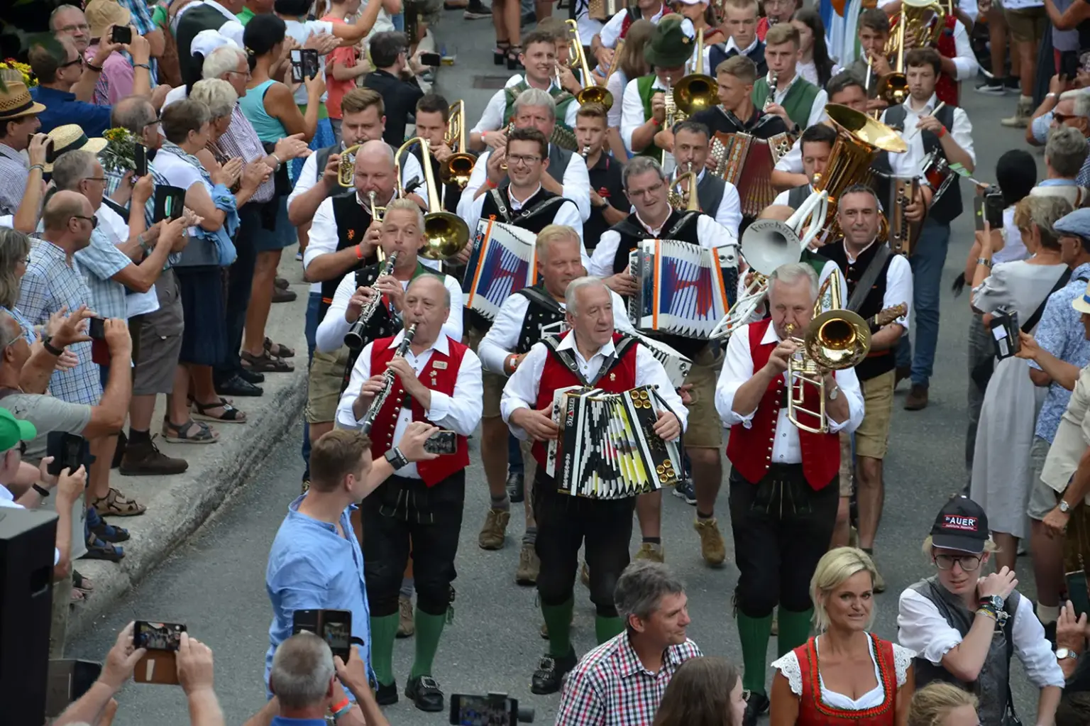 Gasen: Ein ganzes Dorf wird zur Bühne Eine Gruppe von Musikanten marschiert spielend durch eine Straße, gesäumt von zahlreichen ZuschauerInnen