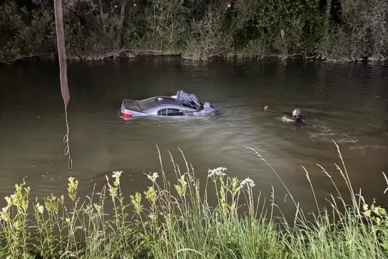 Mehrere Taucher befassen sich in der Nacht mit einem Auto in einem Fluss