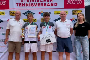 Zwei Burschen mit Pokal, Urkunden und Medaillen bei einer Siegerehrung, neben ihnen zwei Männer und eine Frau als Gratulanten