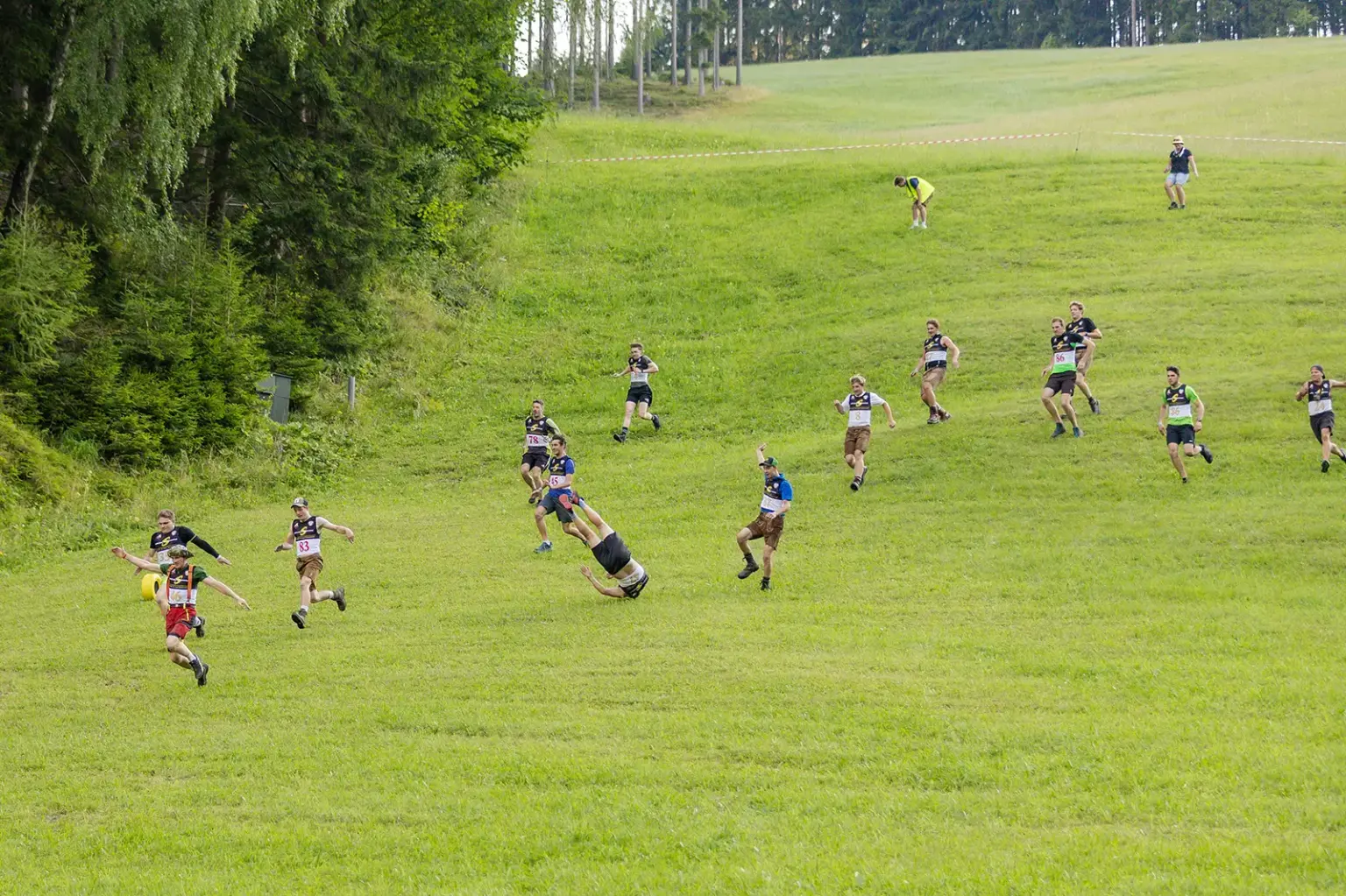 Eine Gruppe junger Männer stürmt in vollem Lauf einen Abhang hinab