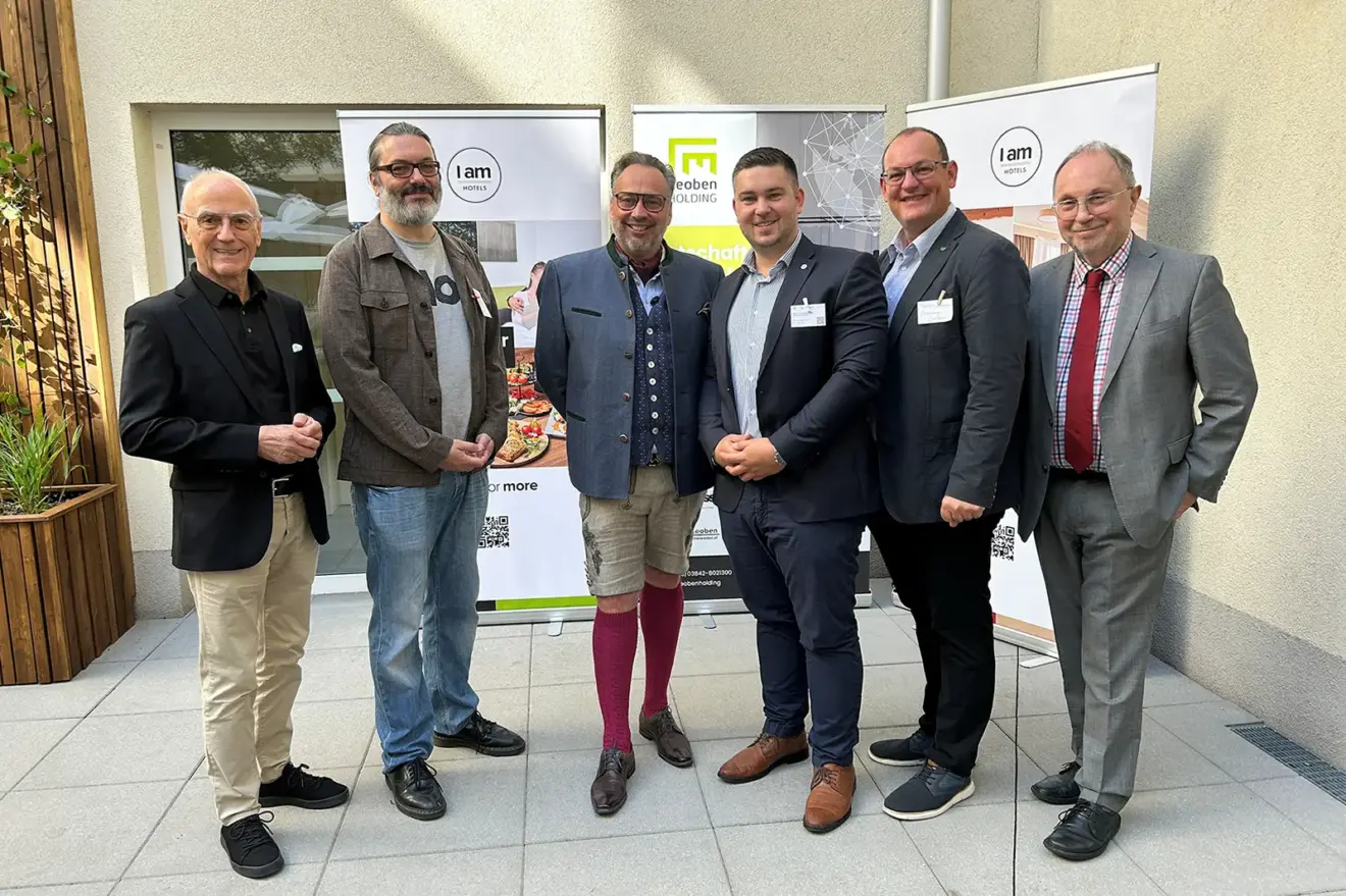 Sechs Männer stehen vor drei Rollups