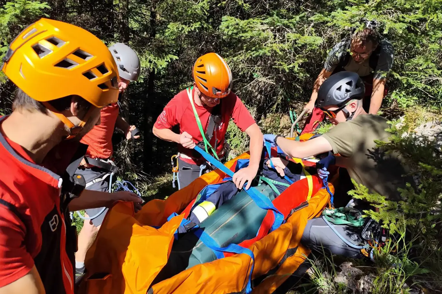 Sanitätsübung der Feuerwehr in Neuberg Mehrere Personen mit Helmen versorgen einen Menschen auf einer Bahre im Wald