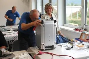 Ein Mann arbeitet an einem Gerät, eine Frau sieht im dabei zu