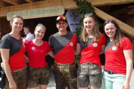 Almfest der Bergrettung Tragöß Vier Frauen und ein Mann in Lederhosen und Bergrettungs-T-Shirts