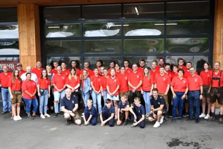 Feuerwehr-Frühschoppen im Laintal Eine Gruppe von rund 50 Personen, großteils in roten T-Shirts, vor einem Hallentor.